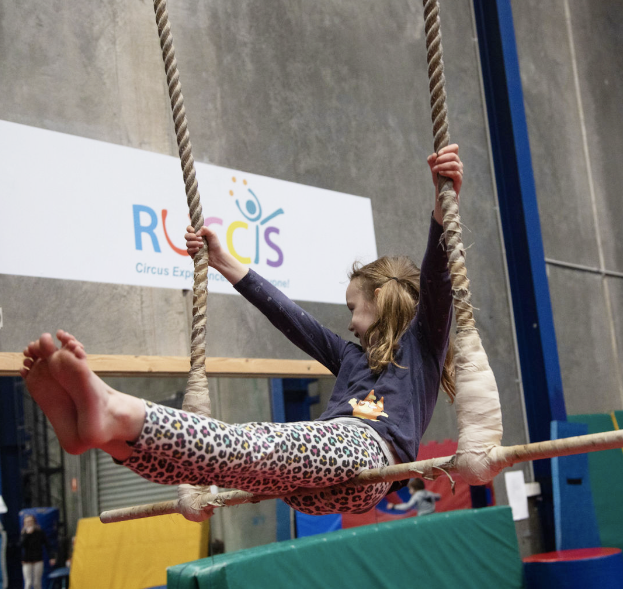 Girl sitting on trapeze